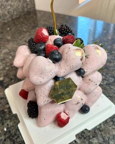 a cake made to look like an elephant with fruit on it's back and the words happy birthday written in gold