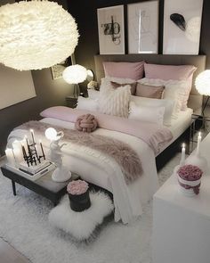 a white bed sitting in a bedroom on top of a fluffy rug next to two lamps