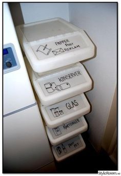 three containers are stacked on top of each other in front of a refrigerator with magnets