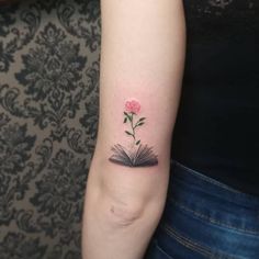 a small book with a flower on the arm