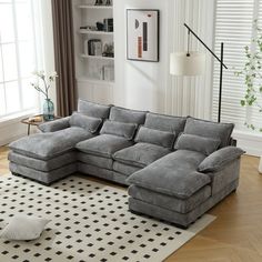 a living room with a gray sectional couch and white rug in front of the window