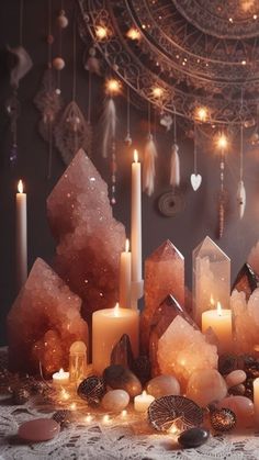 candles and crystals are on a table with lights in the background, surrounded by other decorations