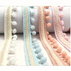 several different types of braids and pom poms on a white tablecloth