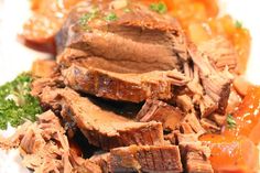 sliced meat and vegetables on a white plate