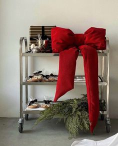 a metal shelf with red bows and shoes on it