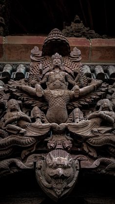 an intricately carved sculpture on the side of a building with many heads and arms