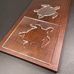 a wooden plaque with two cut out animals on it's sides and one carved in the shape of a turtle