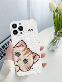 a person holding up a phone case with a cat on it