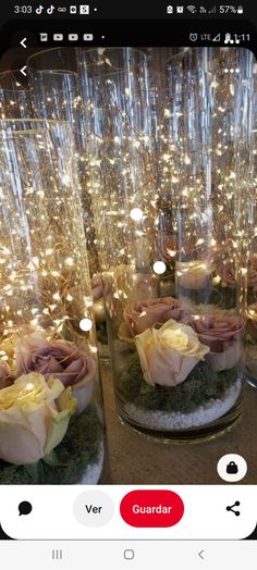 some glass vases with flowers and lights in them