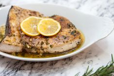 a close up of a plate of food with meat and lemons on it,