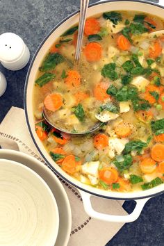 a bowl of soup with carrots and spinach