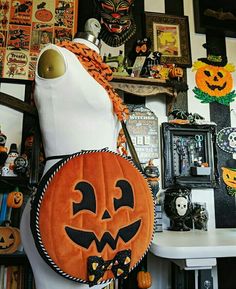 a white mannequin with a pumpkin bag on it's chest and other halloween decorations