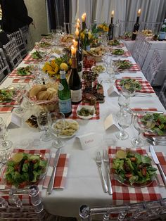 a long table is set with food and wine for an elegant dinner or party event