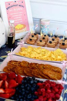 an assortment of breakfast foods are displayed on a table with other food items and desserts