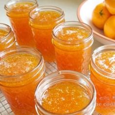 several jars filled with oranges sitting on top of a table