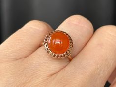 Breathtaking in its classic simplicity and timeless design, this vibrant eye catching carnelian cabochon with a subtle sheen is accentuated with a pave of sparkling fancy cognac red diamonds. Alone or stacked with the rings from our collection,it is absolutely perfect. Carnelian cabochon 11mm Diamonds size 1.1mm 9K solid rose gold Follow us on Instagram: https://www.instagram.com/missionewyork/ Elegant Carnelian Ring In Yellow Gold, Elegant Carnelian Yellow Gold Rings, Elegant Yellow Gold Carnelian Ring, Elegant Carnelian Rings With Polished Finish, Elegant Carnelian Oval Cabochon Ring, Formal Orange Cabochon Ring, Elegant Orange Carnelian Rings, Silk Bracelet, Cognac Diamonds