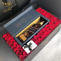 an open box with roses in it and a bottle of booze on the inside