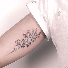 a woman's arm with a flower tattoo on the left side of her arm