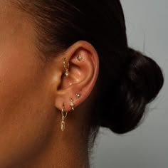 a close up of a person with ear piercings on their ears and behind them is a woman's head