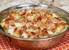 a large metal pan filled with food on top of a red and white checkered table cloth