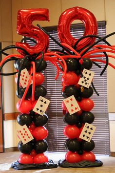 the balloon columns are decorated with black, red and white balloons that spell out the number 50