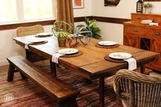 a wooden table with plates and place settings on it