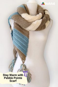 a white mannequin wearing a brown and blue striped scarf