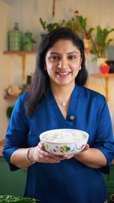 a woman holding a bowl with rice in it