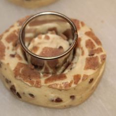 a giraffe print cake with a ring on it's top and two cookies in the background