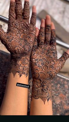 two hands with henna tattoos on them