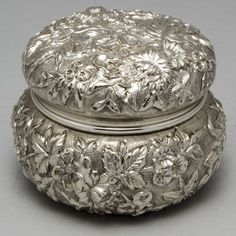 an ornate silver box with flowers on it