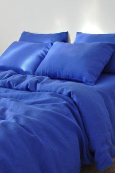 a bed with blue sheets and pillows on it