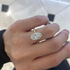 a woman's hand with a diamond ring on it