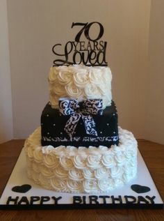 a white and black birthday cake with the number 70 on it's top tier