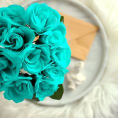 a bouquet of blue roses sitting on top of a white plate