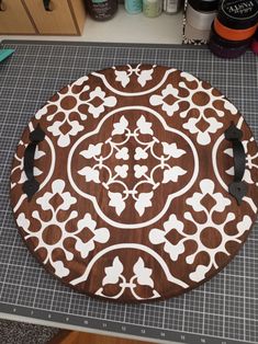 a brown and white cutting board sitting on top of a counter next to scissors, thread and other crafting supplies