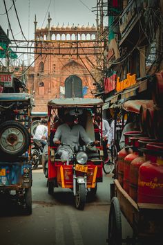 a man riding on the back of a motorcycle down a street next to other vehicles