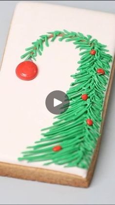 a decorated cookie with green icing and red decorations