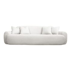 a white couch with four pillows on it's back and one arm facing the camera