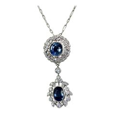 This is part of Chairish’s Fine Jewelry assortment.  Vintage Sapphire Diamond 18K Drop Necklace  This necklace is made in 18K White Gold and features 2 beautiful Blue Sapphires. The style is modern yet bears a vintage drop necklace style. The necklace is 18" long and has (1) oval Sapphire of 1.25 carats the other Sapphire drop is round and weighs .75 carats. This totals 2 carats of Sapphires. Diamond surround the Sapphires in wreath style and the bottom Sapphire has a Diamond surround. The Diamo Luxury Oval Jeweled Necklaces, Luxury Jeweled Oval Necklaces, Formal Oval Necklace With 17 Jewels, Oval Diamond Necklace With Jewels, Formal Oval Necklaces With 17 Jewels, Vintage Diamond Gemstone Necklace, Vintage Diamond Necklace With Gemstones, Exquisite Oval Jewel Necklaces, Classic Oval Jeweled Necklace