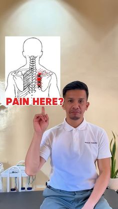 a man sitting down holding up a sign that says pain here? with an image of the back of his neck