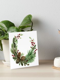 a christmas wreath with pine cones and berries art board print