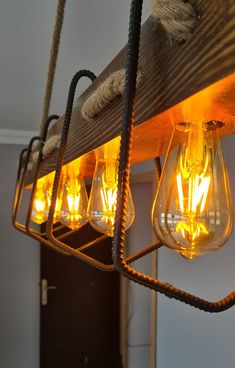 several light bulbs are hanging from a wooden beam