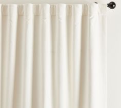 a white curtain hanging on the side of a window with a black metal rod attached to it