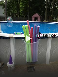 there are many different colored toothbrushes in the cup next to the swimming pool