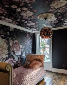 a bedroom with floral wallpaper and wooden floors