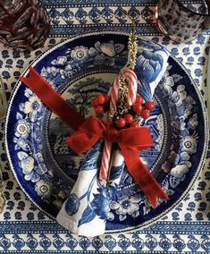 a blue and white plate with candy canes on it next to a red bow