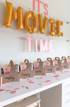 this movie time party has gold balloons and popcorn bags