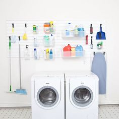 two washers sitting next to each other in front of a wall with cleaning supplies on it