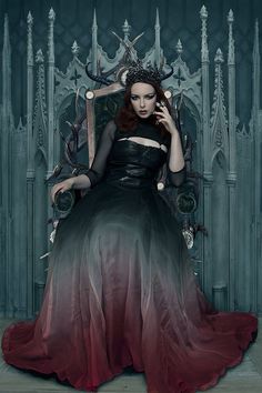 a woman sitting on a throne with her hands in her hair and wearing a black dress